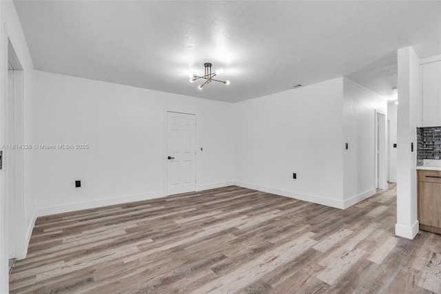 19330 NE 2nd Ave, Miami, FL 33179 - unfurnished room featuring light wood-style flooring, a chandelier, and baseboards