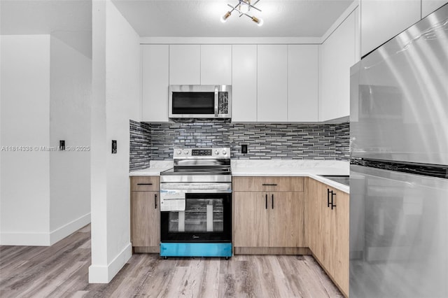 19330 NE 2nd Ave, Miami, FL 33179 - kitchen featuring appliances with stainless steel finishes, light countertops, light wood-style floors, and baseboards