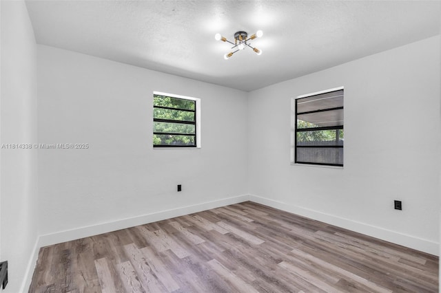 19330 NE 2nd Ave, Miami, FL 33179 - spare room featuring plenty of natural light, a chandelier, wood finished floors, and baseboards