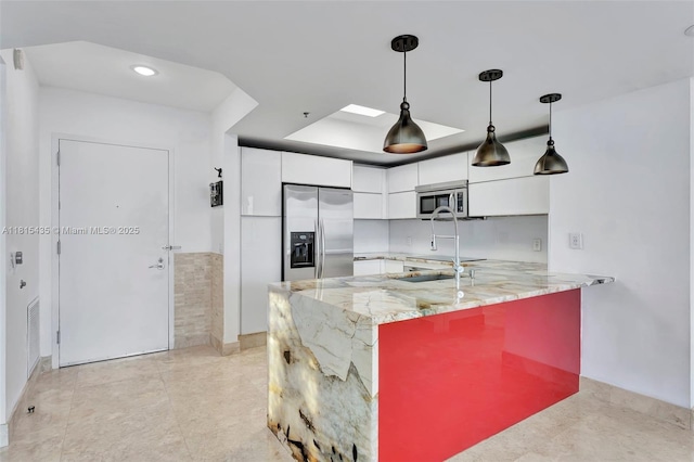 2641 N Flamingo Rd Unit 603N, Sunrise, FL 33323 - kitchen featuring appliances with stainless steel finishes, white cabinetry, a peninsula, modern cabinets, and decorative light fixtures