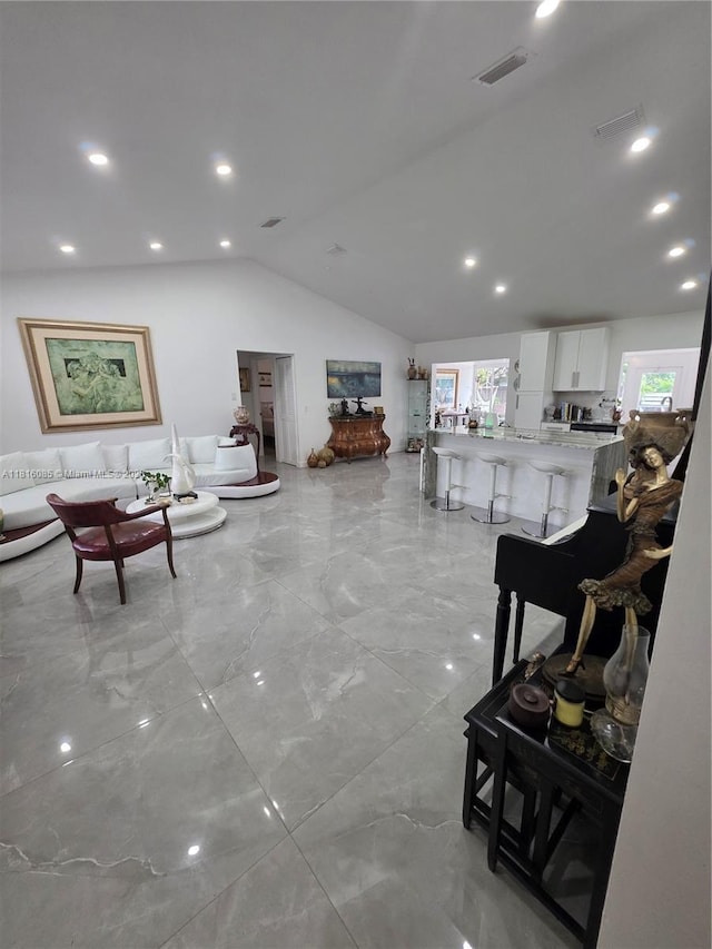 117 SW Fairview Ave, Port St Lucie, FL 34983 - living room with lofted ceiling, light marble finish flooring, and recessed lighting