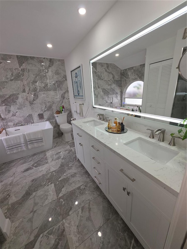 117 SW Fairview Ave, Port St Lucie, FL 34983 - full bath featuring tile walls, toilet, double vanity, a bathtub, and recessed lighting