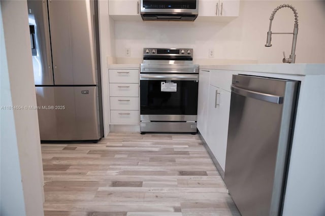 251 NW 76th Ave Unit 208, Margate, FL 33063 - kitchen with stainless steel appliances, light wood-type flooring, white cabinetry, and light countertops