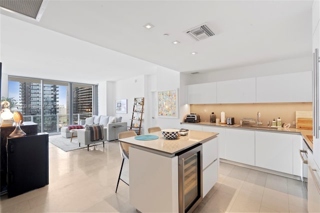 88 SW 7th St Unit 1205, Miami, FL 33130 - kitchen featuring beverage cooler, modern cabinets, white cabinets, a center island, and open floor plan