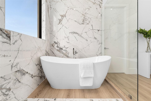 6200 Moss Ranch Rd, Pinecrest, FL 33156 - bathroom with a freestanding bath, tile walls, and wood finished floors