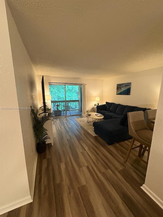 1810 NW 23rd Blvd Unit 103, Gainesville, FL 32605 - living room featuring dark wood-style flooring, a textured wall, and a textured ceiling