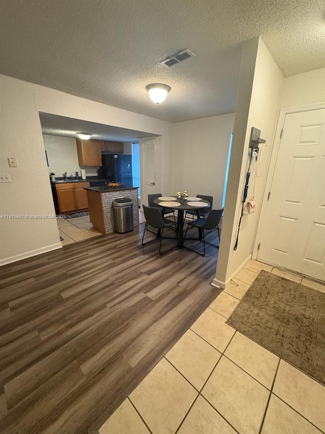 1810 NW 23rd Blvd Unit 103, Gainesville, FL 32605 - dining area featuring a textured ceiling and light wood-style floors