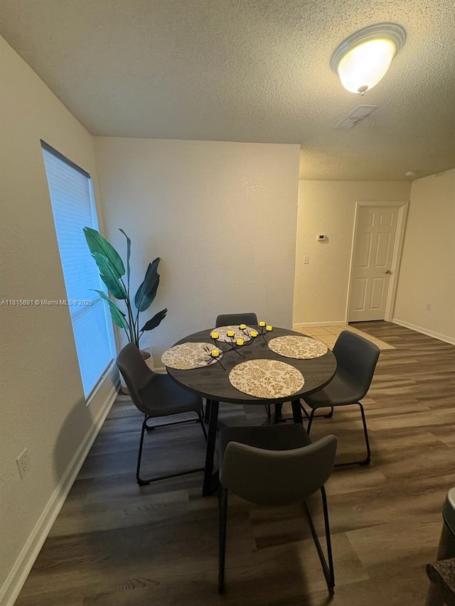 1810 NW 23rd Blvd Unit 103, Gainesville, FL 32605 - dining space featuring dark wood-style flooring and a textured ceiling