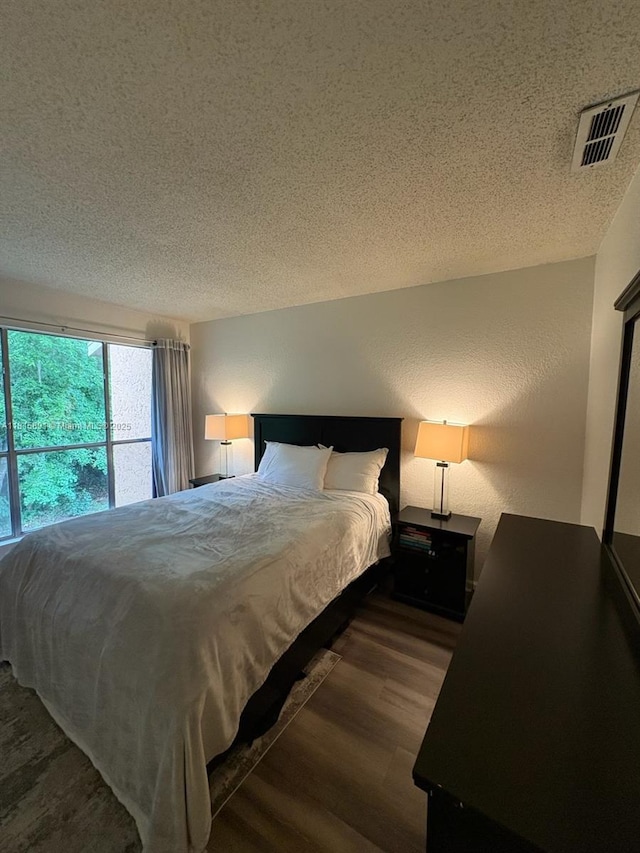 1810 NW 23rd Blvd Unit 103, Gainesville, FL 32605 - bedroom featuring a textured ceiling and wood finished floors