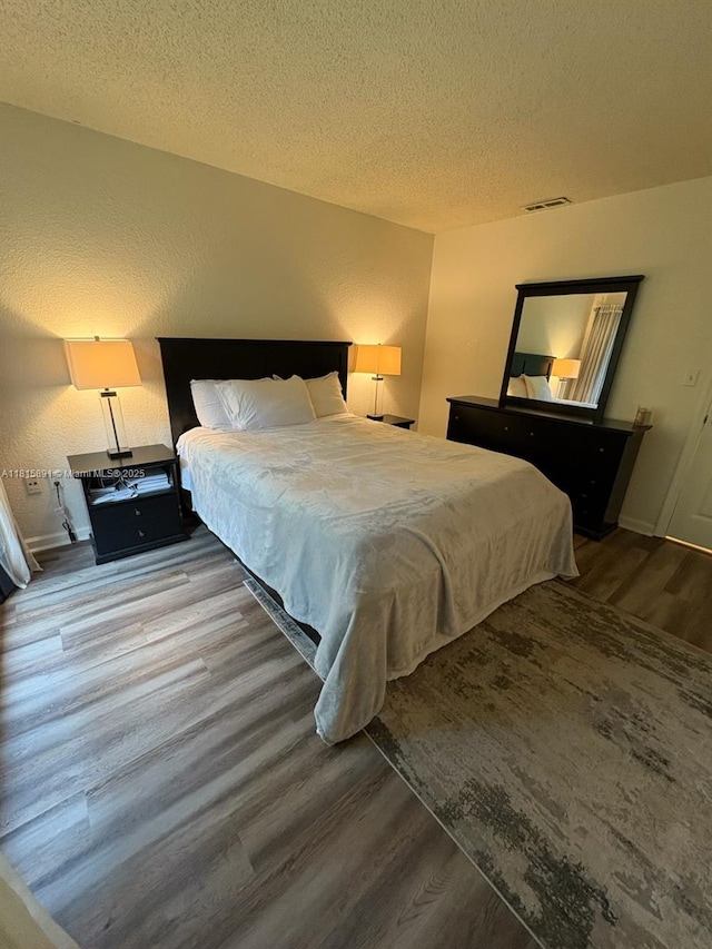 1810 NW 23rd Blvd Unit 103, Gainesville, FL 32605 - bedroom featuring wood finished floors and a textured ceiling
