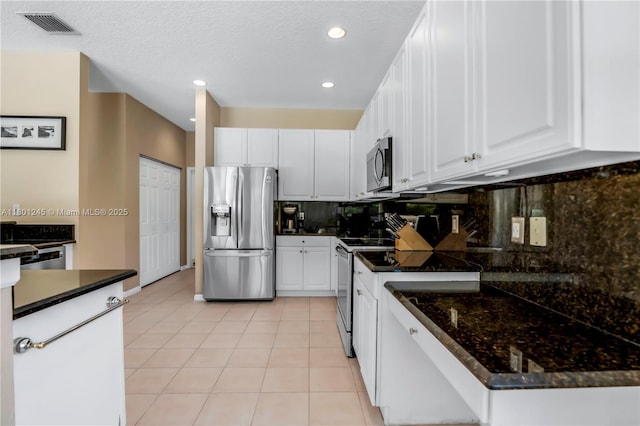 12890 Hyland Cir, Boca Raton, FL 33428 - kitchen with stainless steel appliances, white cabinets, light tile patterned flooring, recessed lighting, and a textured ceiling