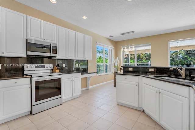 12890 Hyland Cir, Boca Raton, FL 33428 - kitchen with appliances with stainless steel finishes, a sink, dark countertops, tasteful backsplash, and white cabinets