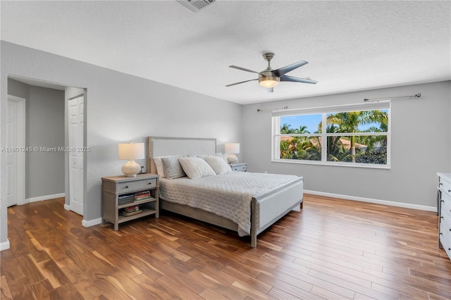 12890 Hyland Cir, Boca Raton, FL 33428 - bedroom featuring wood finished floors, baseboards, a textured ceiling, and a ceiling fan