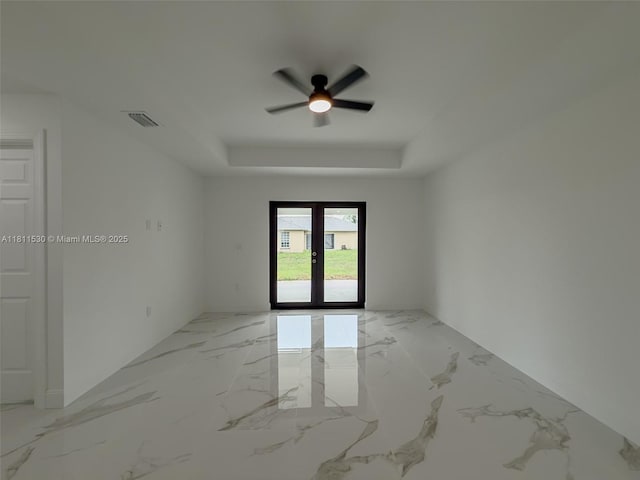 842844 Alabama Rd S, Lehigh Acres, FL 33974 - spare room featuring ceiling fan, a raised ceiling, french doors, and light marble finish floors