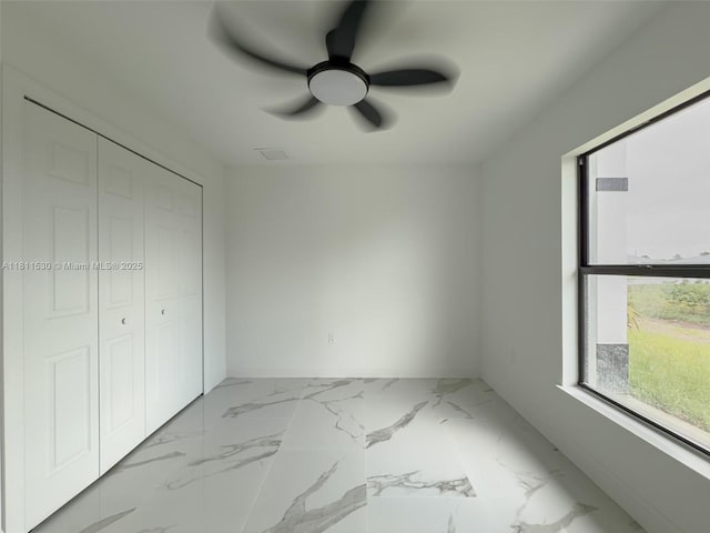 842844 Alabama Rd S, Lehigh Acres, FL 33974 - unfurnished bedroom with a closet, marble finish flooring, baseboards, and ceiling fan