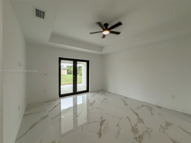 842844 Alabama Rd S, Lehigh Acres, FL 33974 - unfurnished room with french doors, a ceiling fan, a raised ceiling, and light marble finish flooring