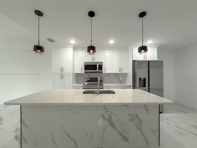 842844 Alabama Rd S, Lehigh Acres, FL 33974 - kitchen featuring stainless steel appliances, a sink, white cabinets, an island with sink, and light marble finish flooring