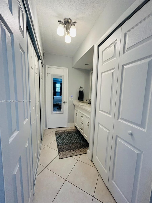 8002 Lagos De Campo Blvd Unit B-107, Tamarac, FL 33321 - mudroom featuring a sink, light tile patterned floors, and a textured ceiling