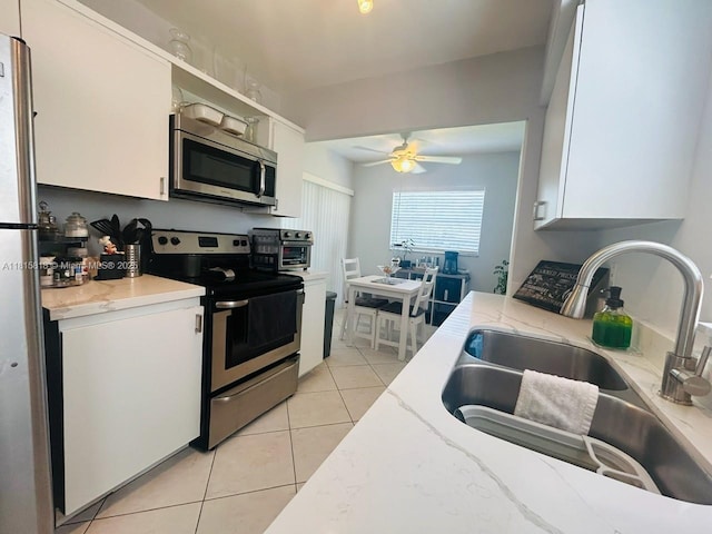 8002 Lagos De Campo Blvd Unit B-107, Tamarac, FL 33321 - kitchen featuring appliances with stainless steel finishes, a sink, light tile patterned floors, white cabinets, and a ceiling fan