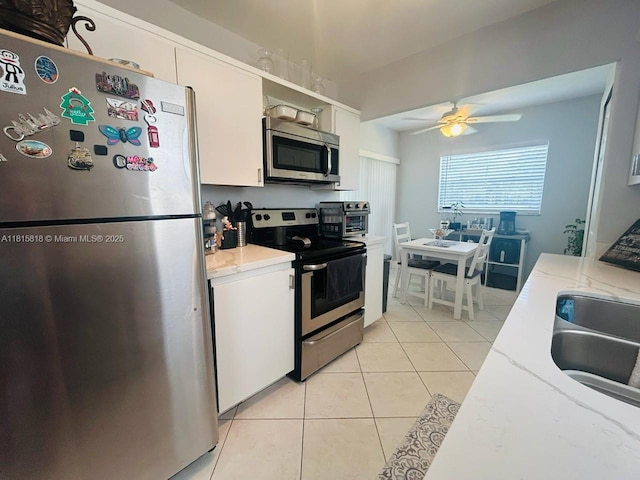 8002 Lagos De Campo Blvd Unit B-107, Tamarac, FL 33321 - kitchen with appliances with stainless steel finishes, a ceiling fan, light tile patterned flooring, and white cabinetry