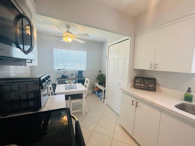 8002 Lagos De Campo Blvd Unit B-107, Tamarac, FL 33321 - kitchen with stainless steel microwave, electric range oven, white cabinetry, light tile patterned flooring, and ceiling fan