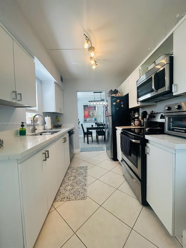 8002 Lagos De Campo Blvd Unit B-107, Tamarac, FL 33321 - kitchen with stainless steel appliances, a sink, light countertops, light tile patterned floors, and white cabinetry