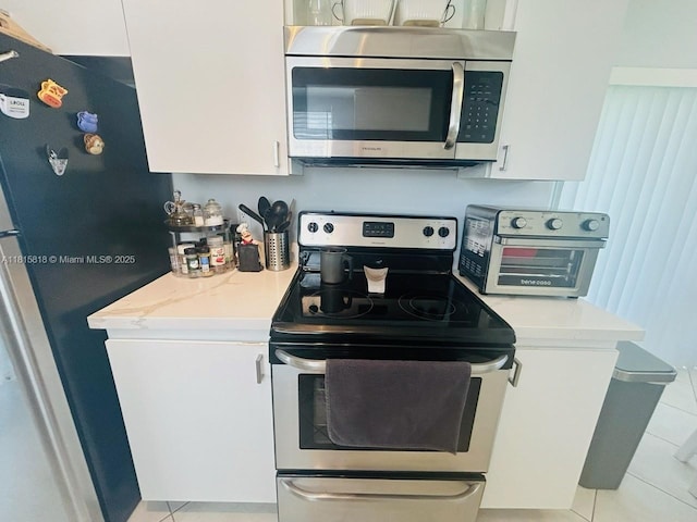 8002 Lagos De Campo Blvd Unit B-107, Tamarac, FL 33321 - kitchen with appliances with stainless steel finishes, light countertops, light tile patterned floors, and white cabinetry