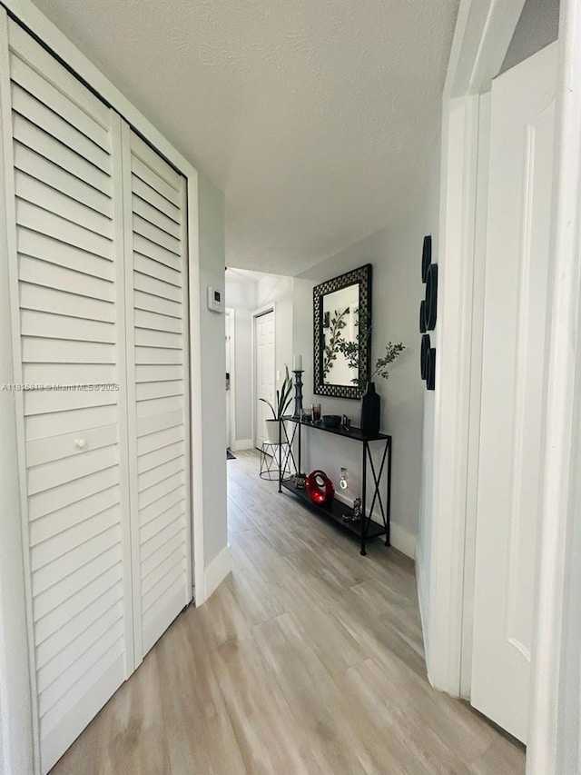 8002 Lagos De Campo Blvd Unit B-107, Tamarac, FL 33321 - hallway featuring light wood finished floors, baseboards, and a textured ceiling