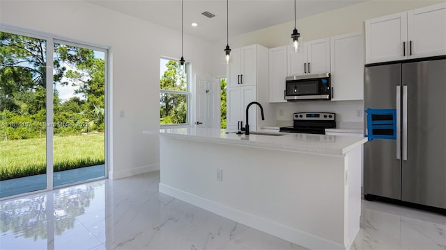 1351 Sulstone Dr, Punta Gorda, FL 33983 - kitchen with stainless steel appliances, baseboards, light marble finish flooring, an island with sink, and white cabinets