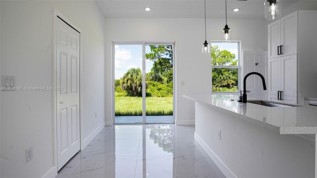 1351 Sulstone Dr, Punta Gorda, FL 33983 - kitchen with light stone counters, baseboards, a sink, light marble finish floors, and recessed lighting