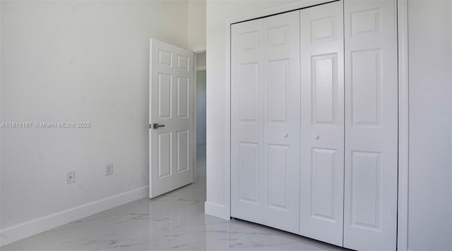 1351 Sulstone Dr, Punta Gorda, FL 33983 - unfurnished bedroom featuring baseboards, light marble finish flooring, and a closet