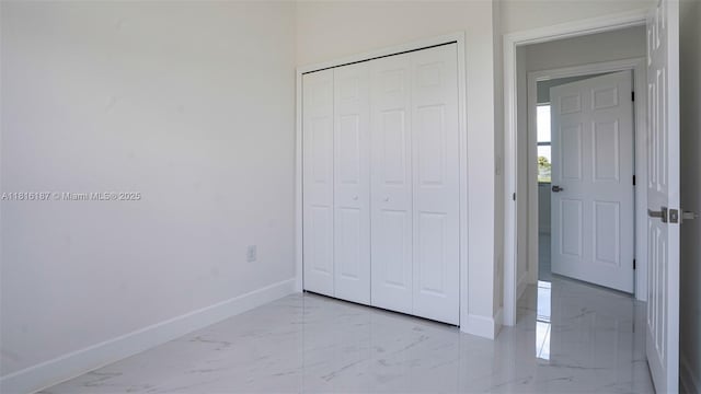 1351 Sulstone Dr, Punta Gorda, FL 33983 - unfurnished bedroom featuring marble look tile flooring, baseboards, and a closet