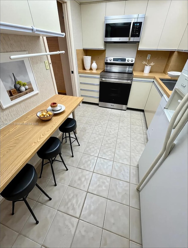 1000 Quayside Te Unit 410, Miami, FL 33138 - kitchen with appliances with stainless steel finishes, light countertops, white cabinets, and light tile patterned floors