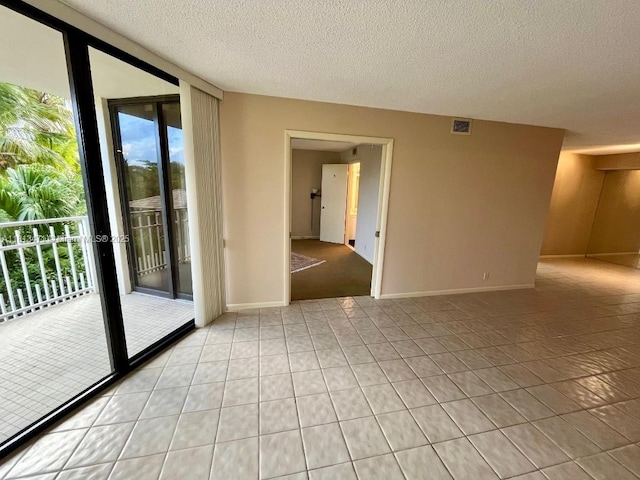 1000 Quayside Te Unit 410, Miami, FL 33138 - empty room featuring expansive windows, plenty of natural light, light tile patterned floors, a textured ceiling, and baseboards