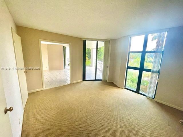 1000 Quayside Te Unit 410, Miami, FL 33138 - carpeted spare room featuring healthy amount of natural light, baseboards, and a textured ceiling