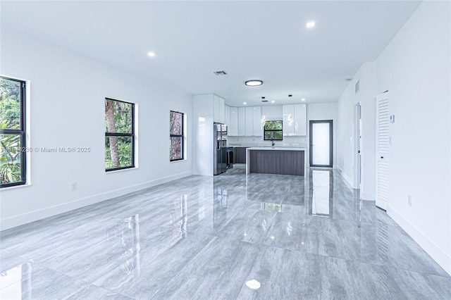 2725 NW 7th St, Fort Lauderdale, FL 33311 - unfurnished living room featuring healthy amount of natural light, recessed lighting, baseboards, and light marble finish floors