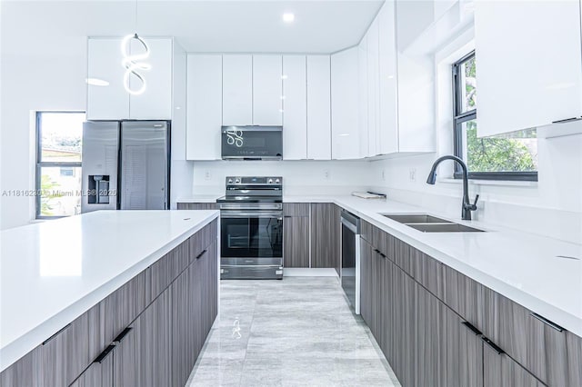 2725 NW 7th St, Fort Lauderdale, FL 33311 - kitchen with stainless steel appliances, a sink, modern cabinets, white cabinetry, and light countertops