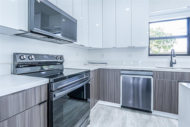 2725 NW 7th St, Fort Lauderdale, FL 33311 - kitchen featuring modern cabinets, stainless steel appliances, a sink, and light countertops