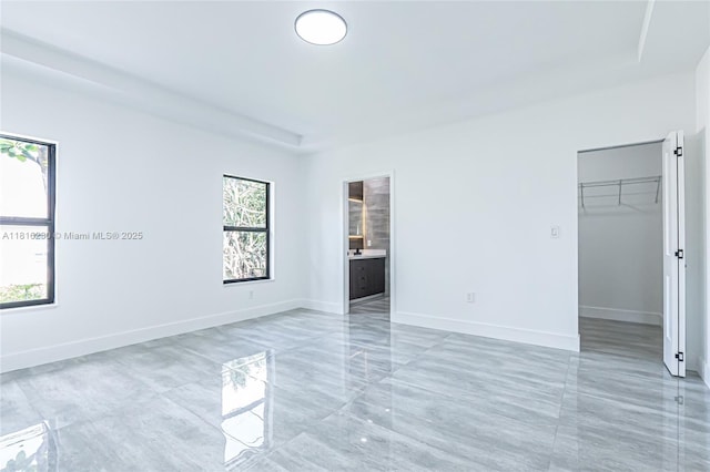 2725 NW 7th St, Fort Lauderdale, FL 33311 - unfurnished bedroom with a walk in closet, baseboards, ensuite bath, and a closet