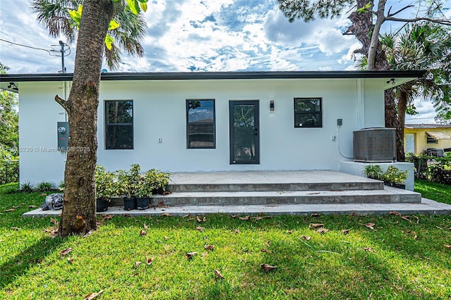 2725 NW 7th St, Fort Lauderdale, FL 33311 - back of property with stucco siding, a yard, and central air condition unit