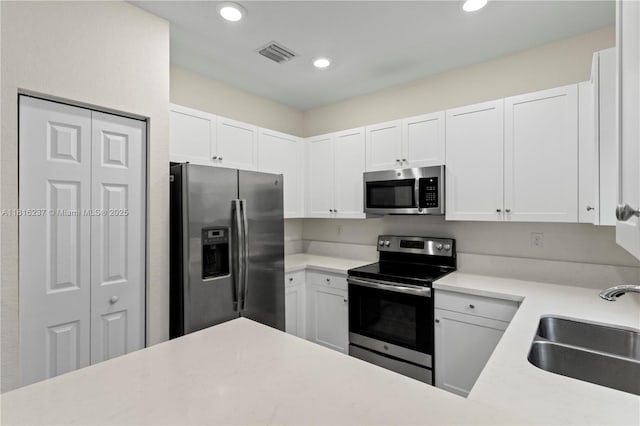 6496 S Anise Ct, Davie, FL 33314 - kitchen featuring appliances with stainless steel finishes, a sink, light countertops, white cabinetry, and recessed lighting