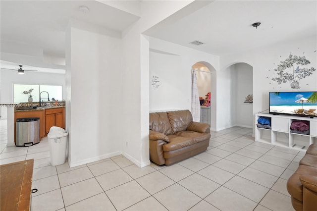 4441 SW Savona Blvd, Port St Lucie, FL 34953 - living room featuring arched walkways, light tile patterned flooring, a ceiling fan, and baseboards