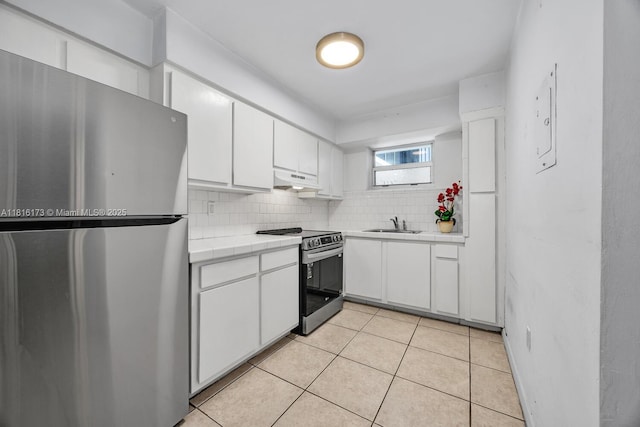 2465 SW 18th Ave Unit 3210, Miami, FL 33145 - kitchen with appliances with stainless steel finishes, tile countertops, under cabinet range hood, white cabinets, and a sink