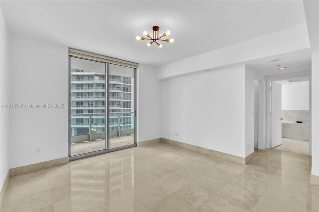1331 Brickell Bay Dr Unit 1808, Miami, FL 33131 - tiled empty room featuring a chandelier, expansive windows, and baseboards