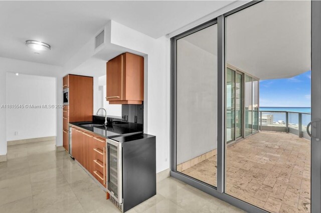 1331 Brickell Bay Dr Unit 1808, Miami, FL 33131 - kitchen with a sink, a wall of windows, dark countertops, brown cabinetry, and wine cooler