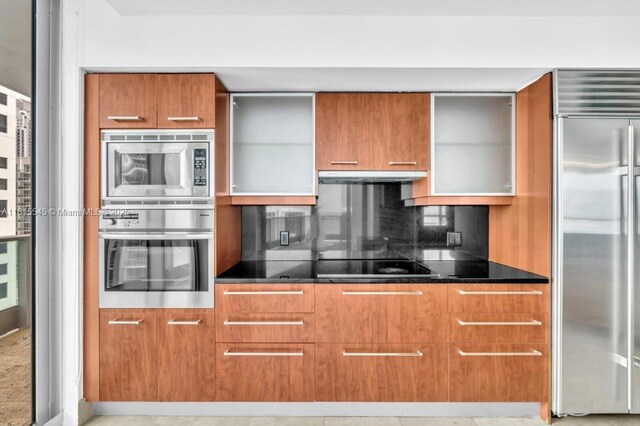 1331 Brickell Bay Dr Unit 1808, Miami, FL 33131 - kitchen featuring built in appliances, brown cabinets, modern cabinets, under cabinet range hood, and decorative backsplash