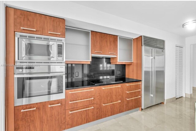 1331 Brickell Bay Dr Unit 1808, Miami, FL 33131 - kitchen featuring built in appliances, brown cabinetry, and backsplash