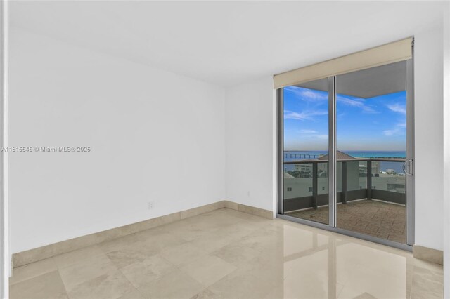 1331 Brickell Bay Dr Unit 1808, Miami, FL 33131 - empty room with a wall of windows, baseboards, and a water view