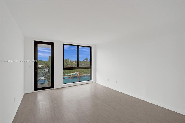 9800 W Bay Harbor Dr Unit 401, Bay Harbor Islands, FL 33154 - spare room featuring wood finished floors, expansive windows, and baseboards