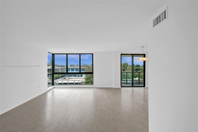 9800 W Bay Harbor Dr Unit 401, Bay Harbor Islands, FL 33154 - spare room featuring a wall of windows, wood finished floors, and baseboards